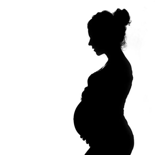 Schattenbild der schwangeren Frau mit Baby nach innen